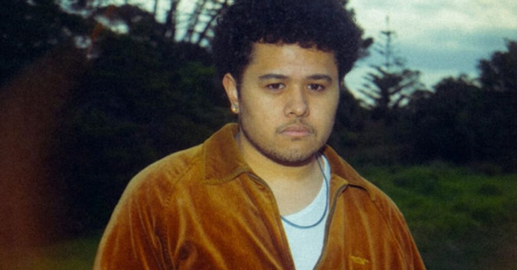 Cover photo of Polynesian artist Hales standing outdoors, wearing a vintage-style brown jacket, with a serene natural background